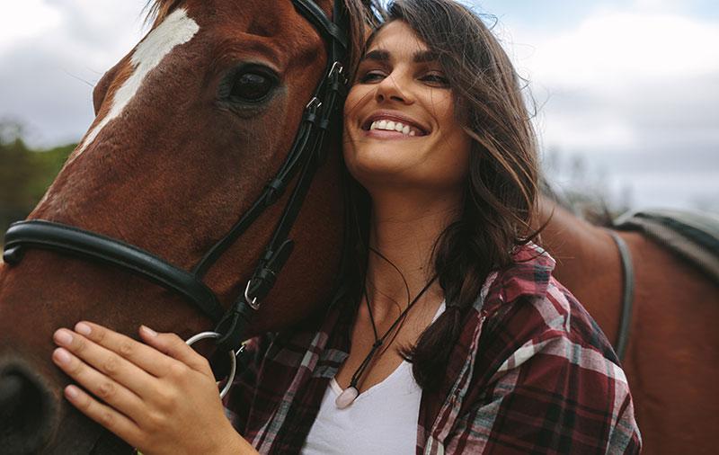 微笑的女人拥抱马